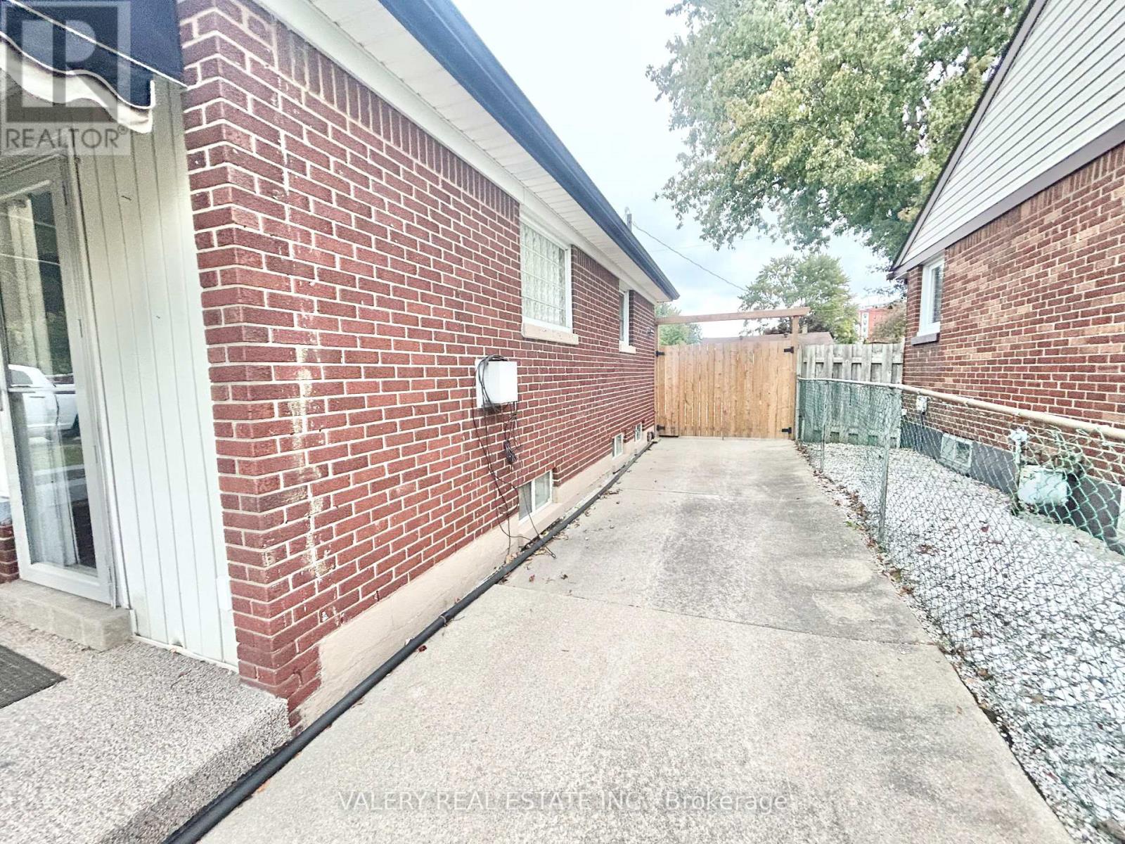 A red brick building with a sign that says "REALTOR" on the top left corner.
