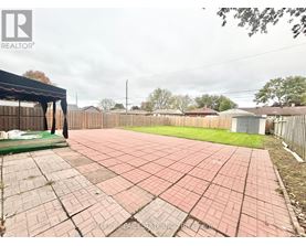 A backyard with a brick patio and a pool table.