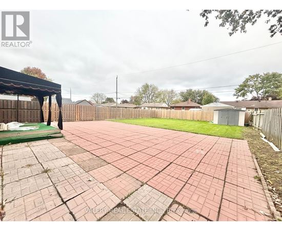 A backyard with a brick patio and a pool table.