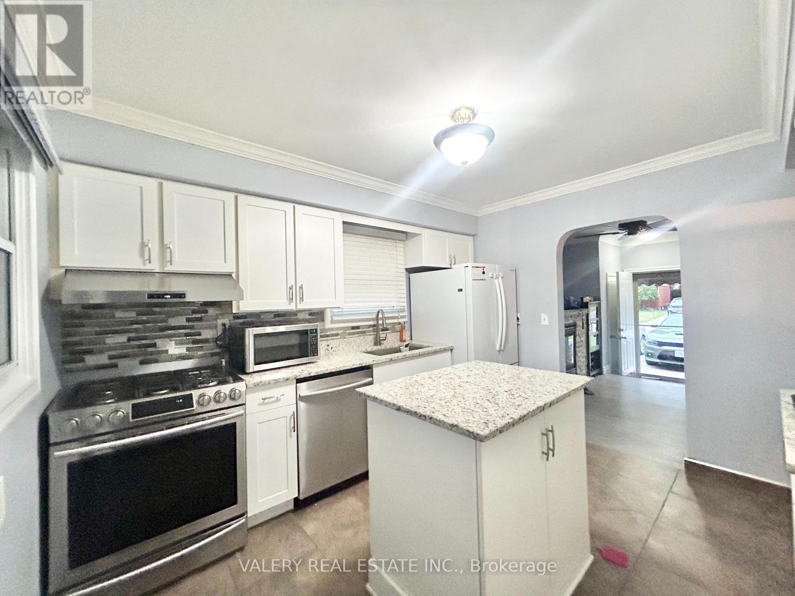A kitchen with white cabinets and stainless steel appliances.