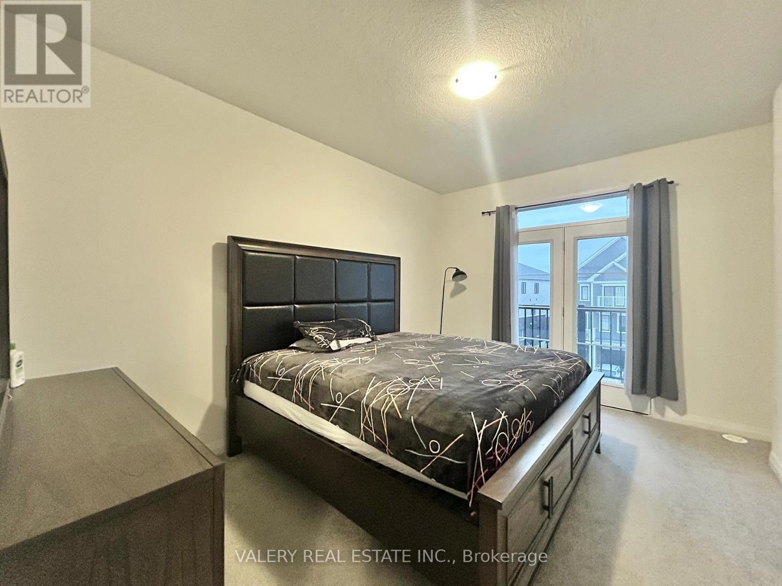 A bedroom with a large bed and a balcony.