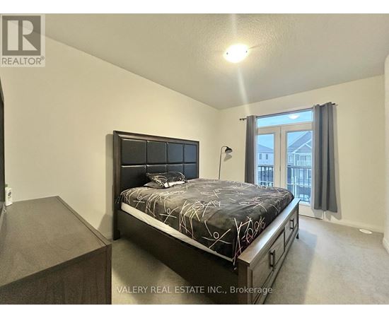 A bedroom with a large bed and a balcony.