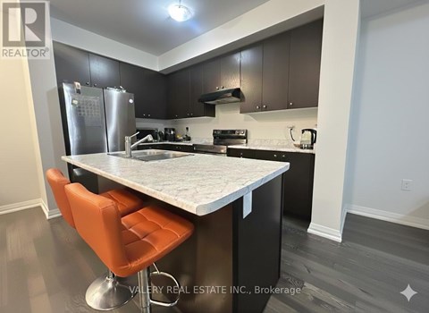 A kitchen with a table and chairs in front of it.