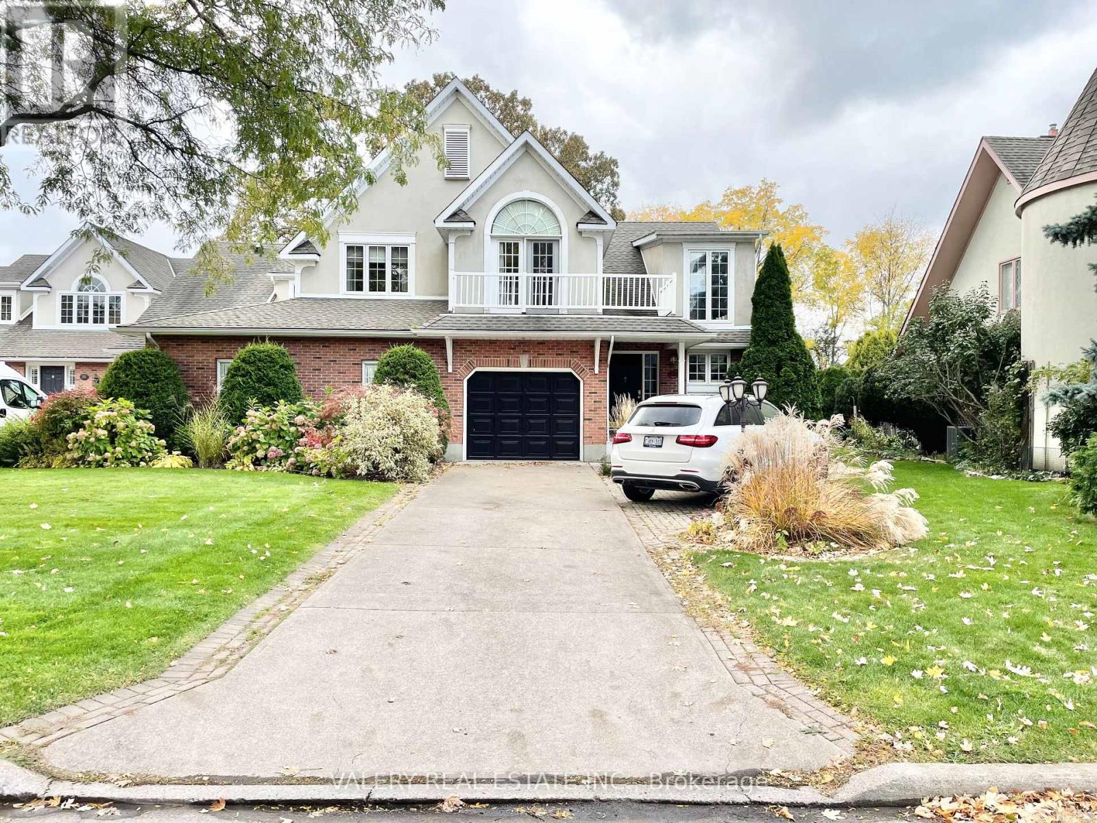 A large house with a driveway and a car parked in front.