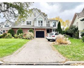 A large house with a driveway and a car parked in front.
