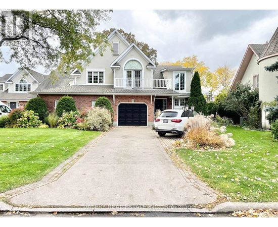 A large house with a driveway and a car parked in front.