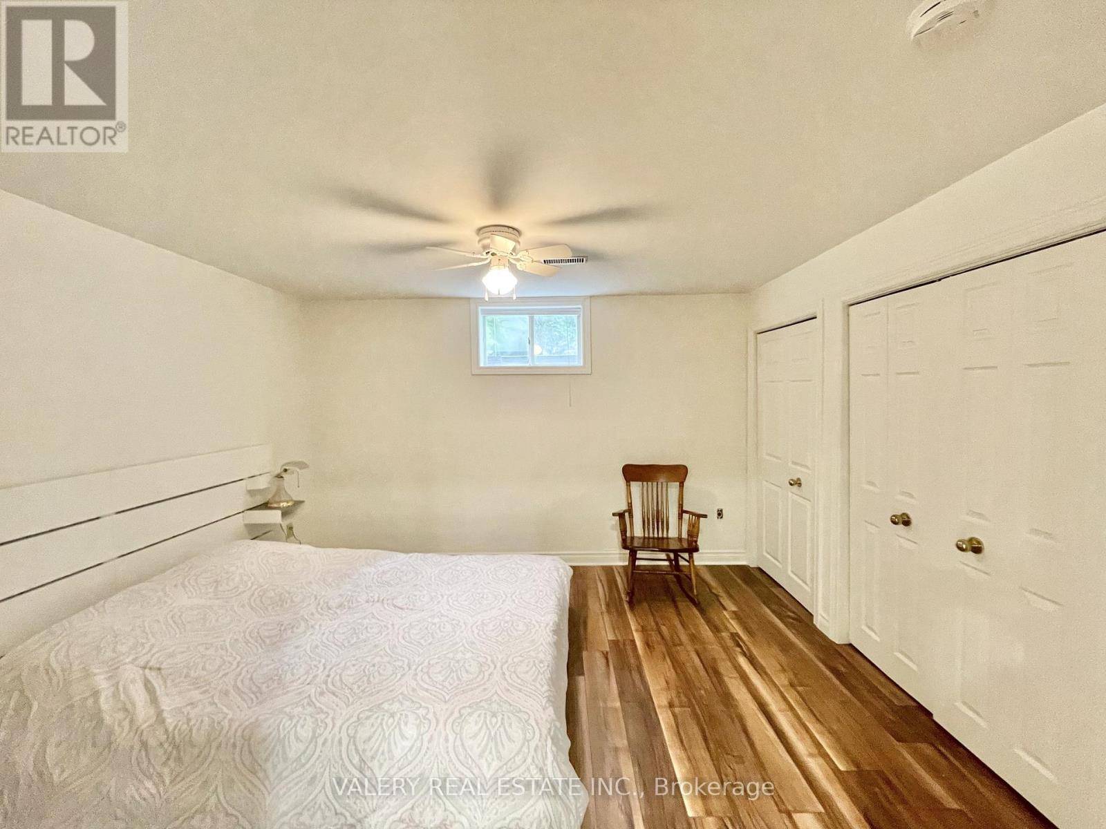 A bedroom with a bed, a chair, and a window.