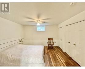 A bedroom with a bed, a chair, and a window.