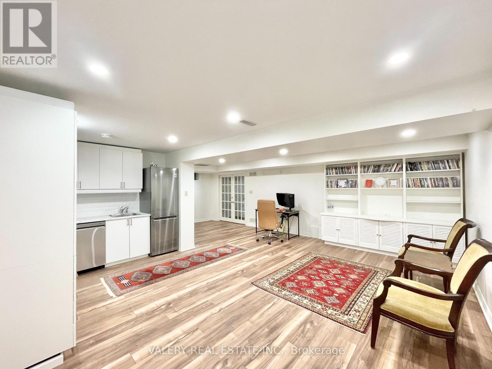 A living room with a refrigerator, a TV, and a rug.