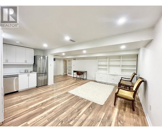A spacious kitchen with white cabinets and a wooden floor.