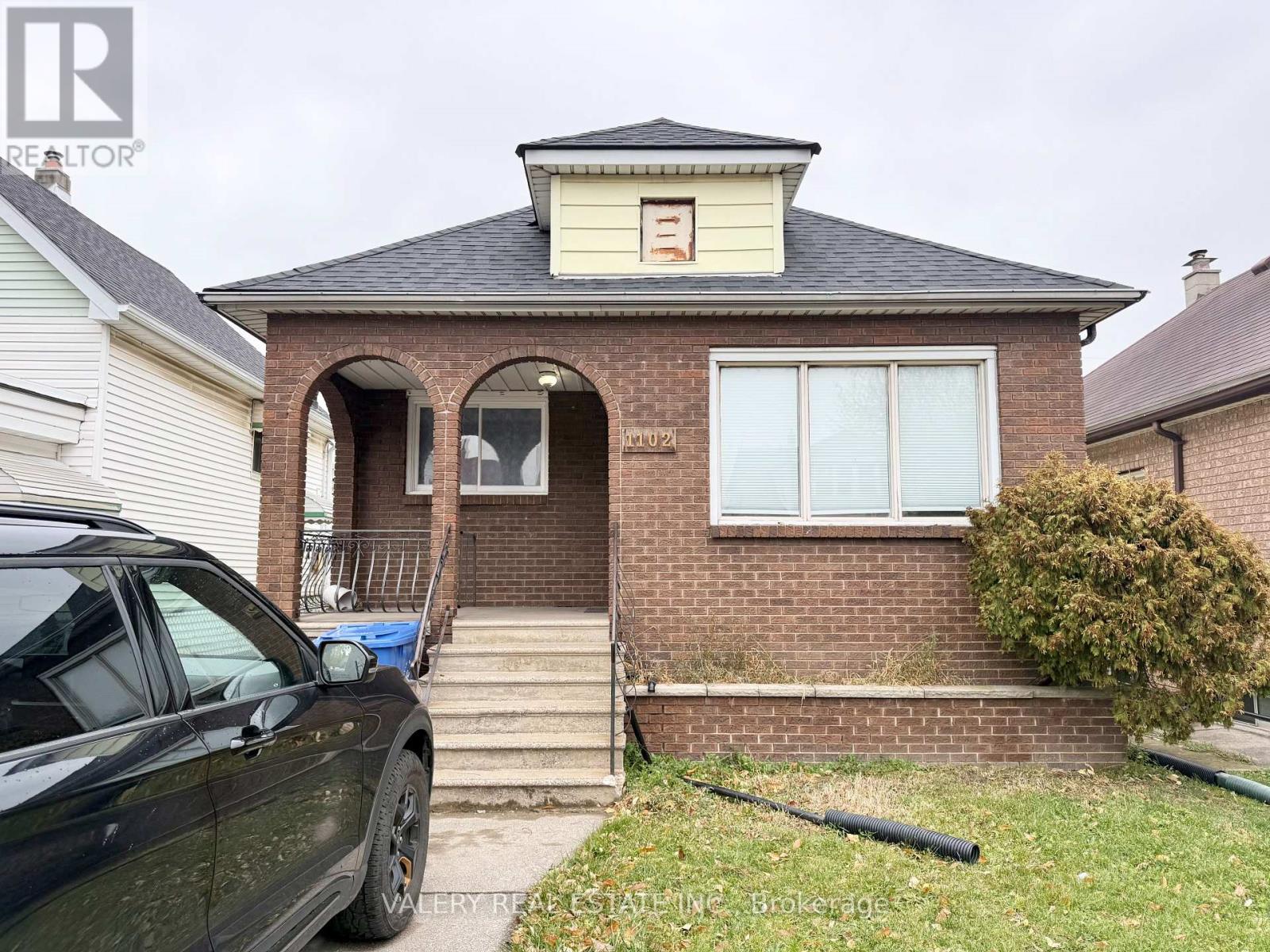 A house with a car parked in front.