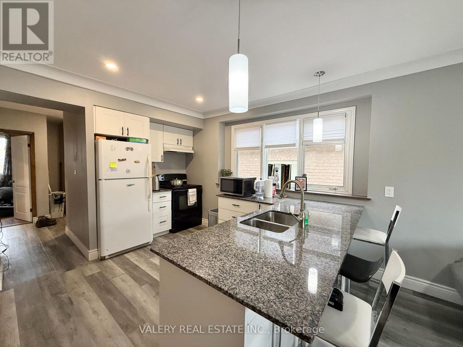 A kitchen with a granite countertop and a white refrigerator.
