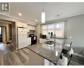 A kitchen with a granite countertop and a white refrigerator.