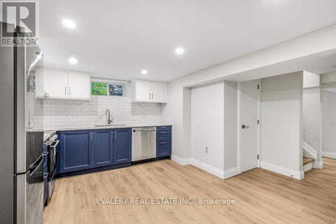 A kitchen with blue cabinets and a refrigerator.