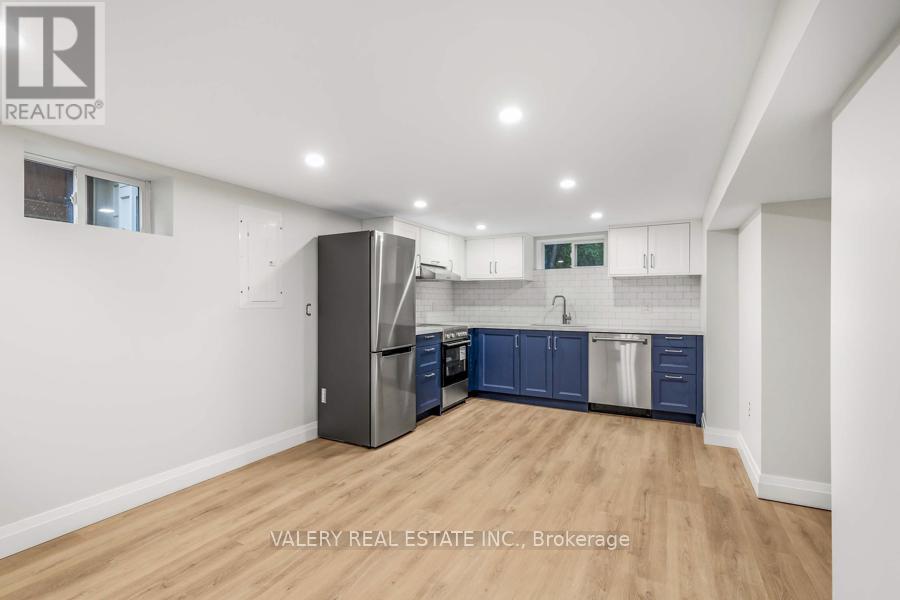 A kitchen with a refrigerator, cabinets, and a countertop.