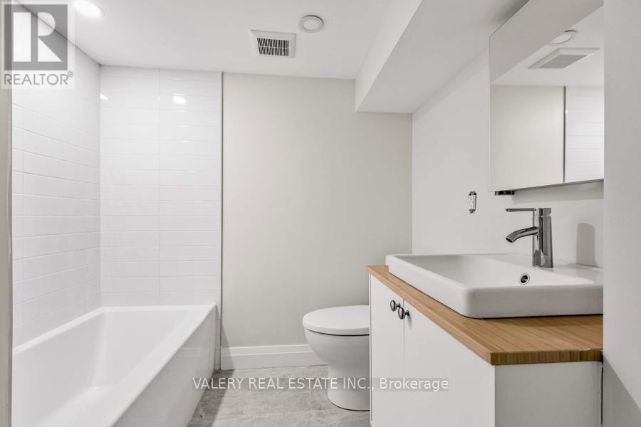 A white bathroom with a wooden counter top and a white sink.