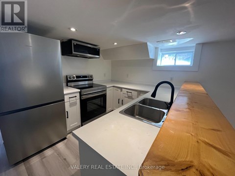 A kitchen with a stainless steel refrigerator, oven, and microwave.