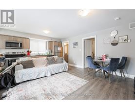 A living room with a couch, chairs, and a dining table.