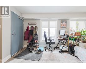 A room with a blue door, a desk with a computer, and a chair.