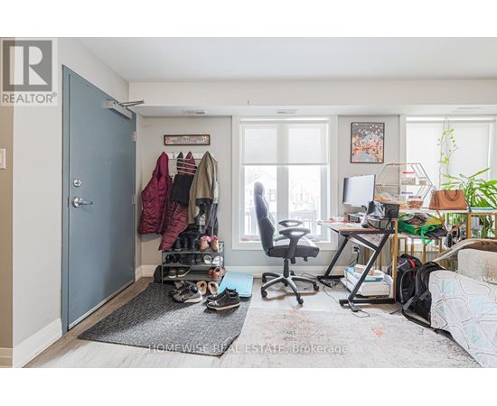 A room with a blue door, a desk with a computer, and a chair.