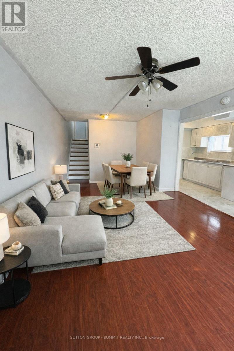 A living room with a grey couch, a coffee table, and a ceiling fan.