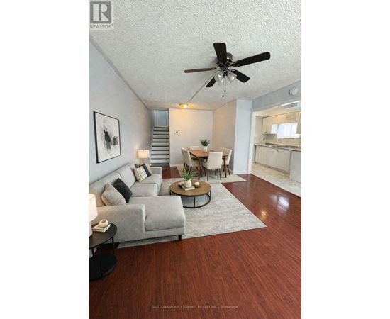 A living room with a grey couch, a coffee table, and a ceiling fan.