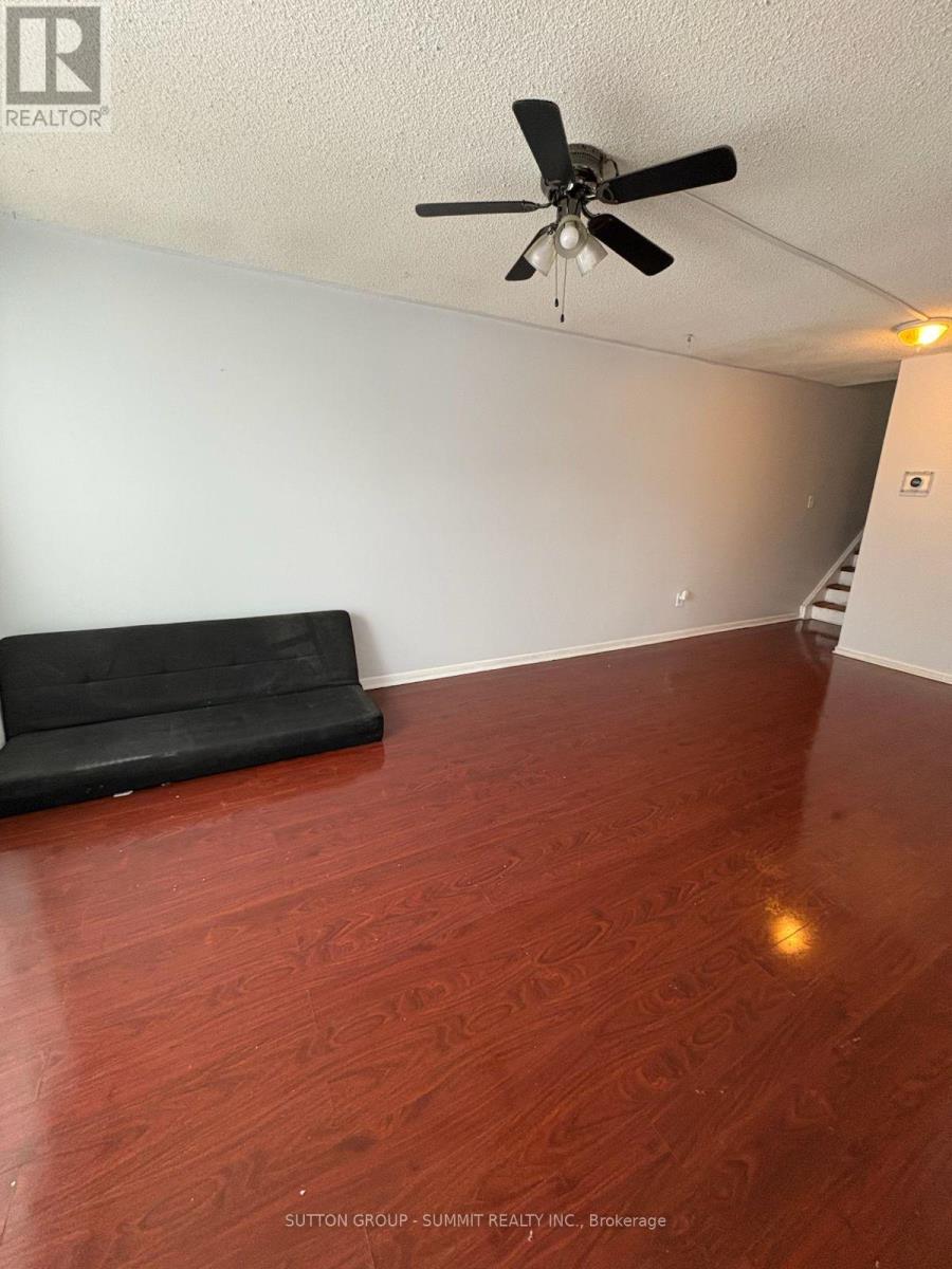 A room with a ceiling fan and a black couch.
