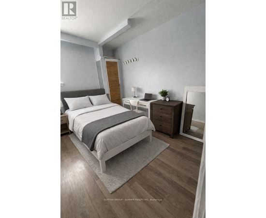 A bedroom with a bed, nightstand, and chair.