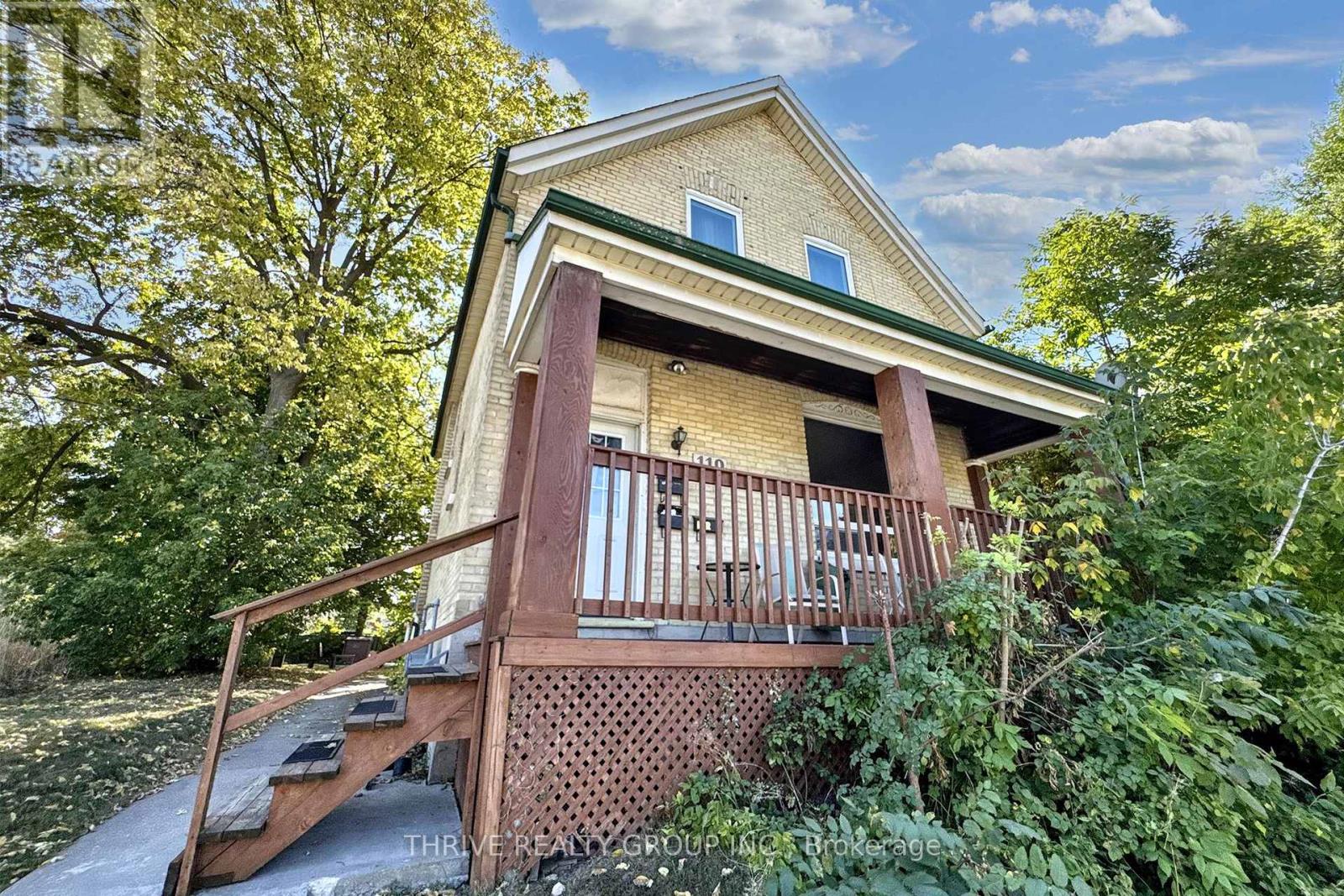 A house with a porch surrounded by trees.