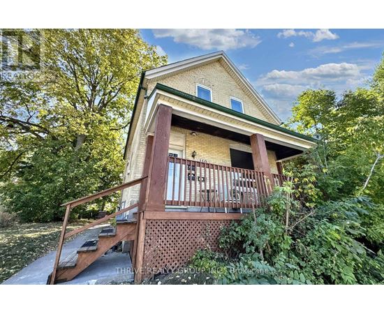 A house with a porch surrounded by trees.