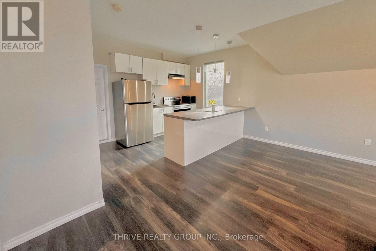 A kitchen with wood flooring and a white island.
