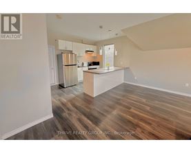 A kitchen with wood flooring and a white island.