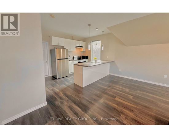 A kitchen with wood flooring and a white island.