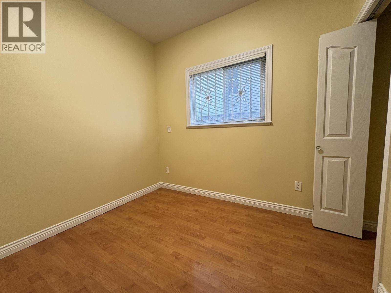 A room with a window and wooden flooring.