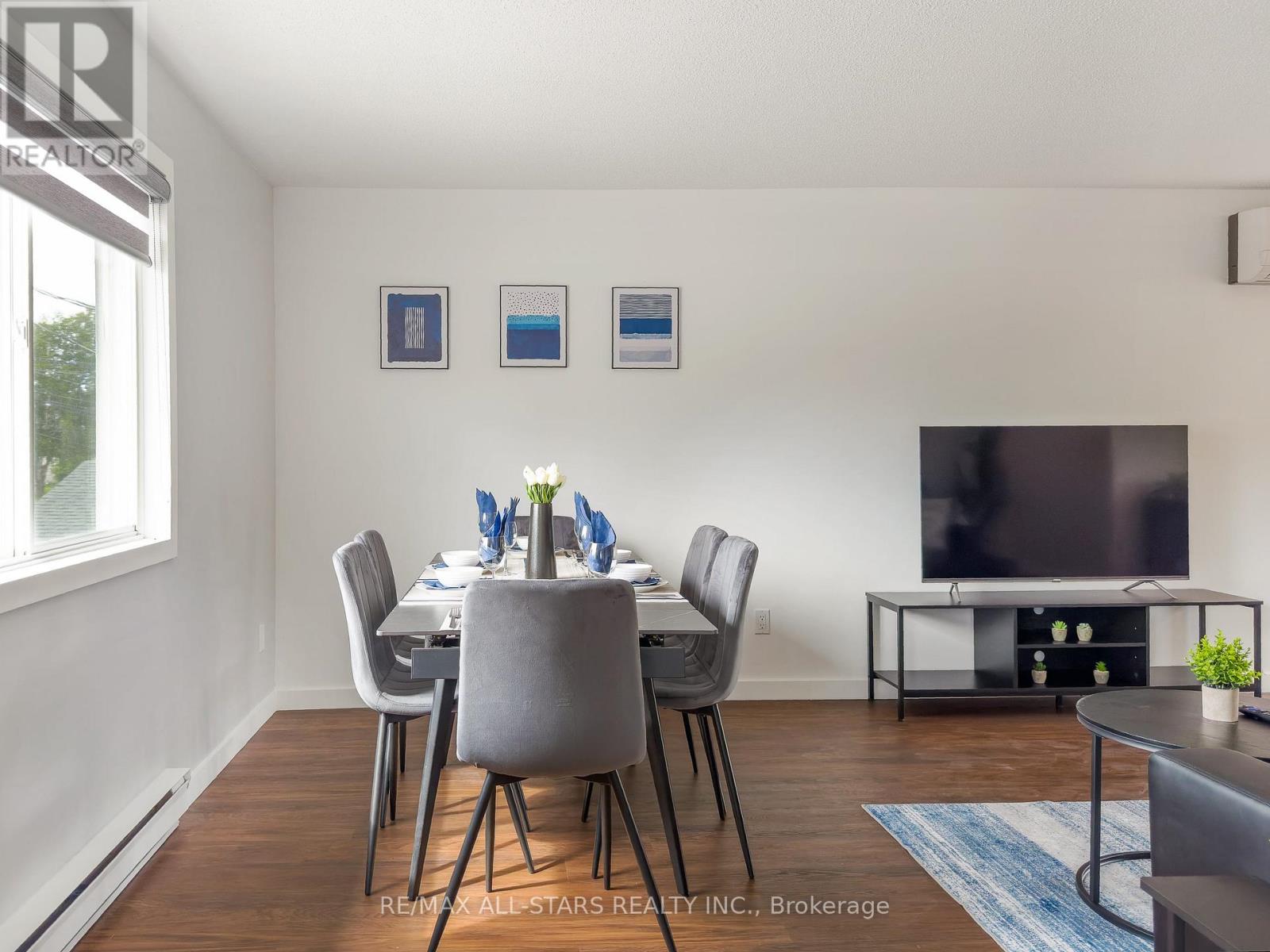 A dining room with a table set for two and chairs around it.