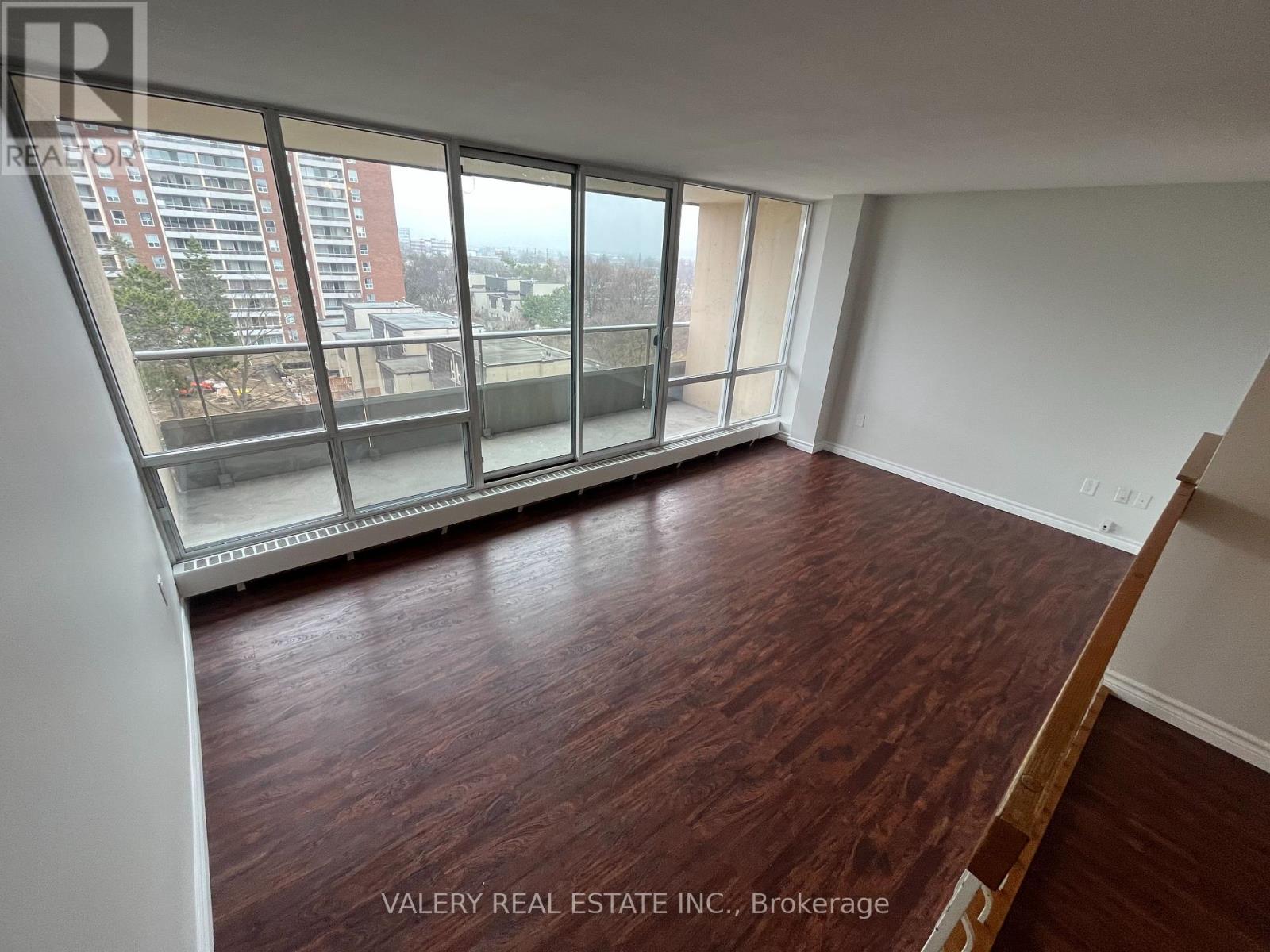A dining room with a table set for two and a television mounted on the wall.