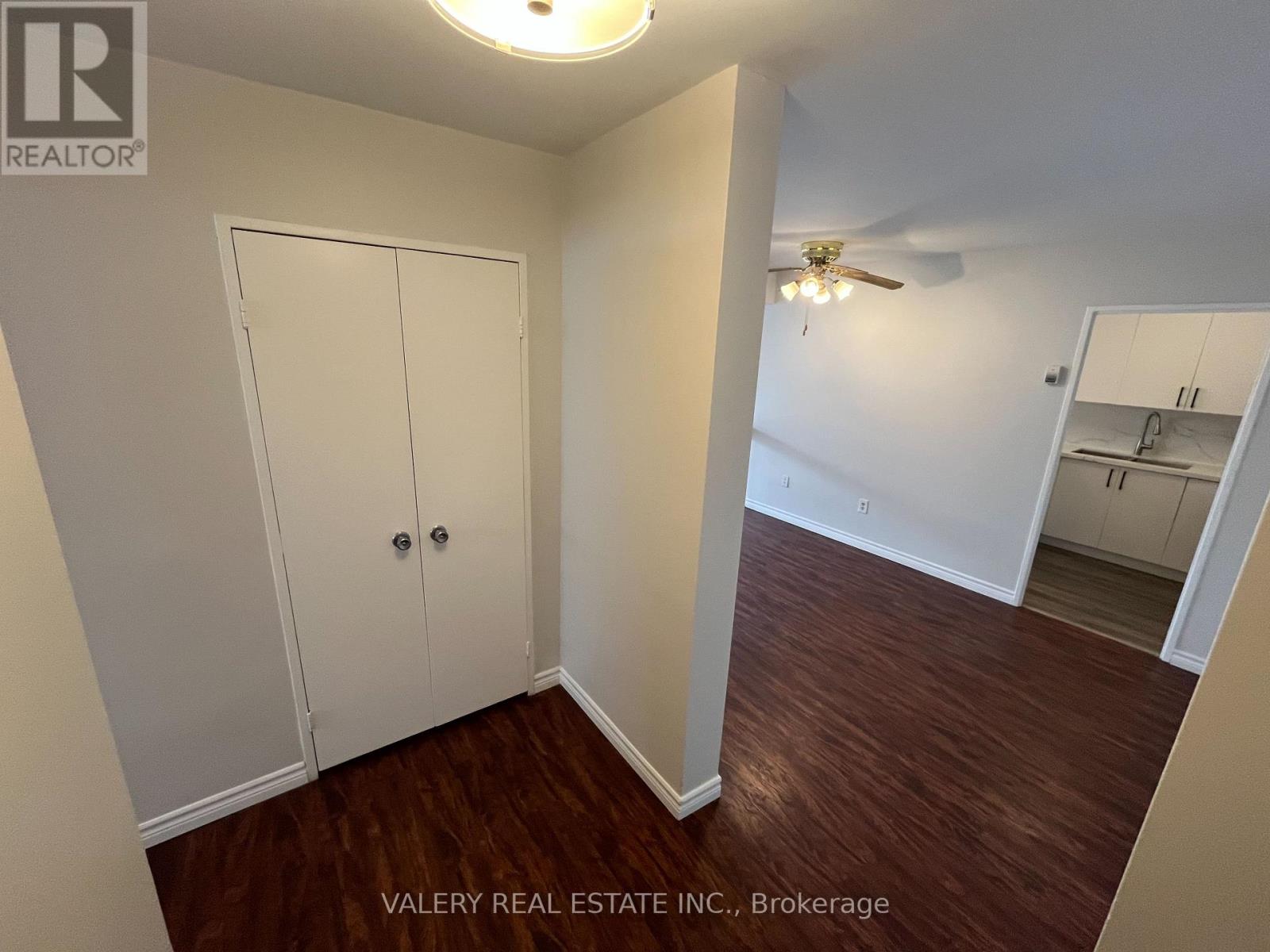 A kitchen with white cabinets and appliances, a microwave, and a refrigerator.