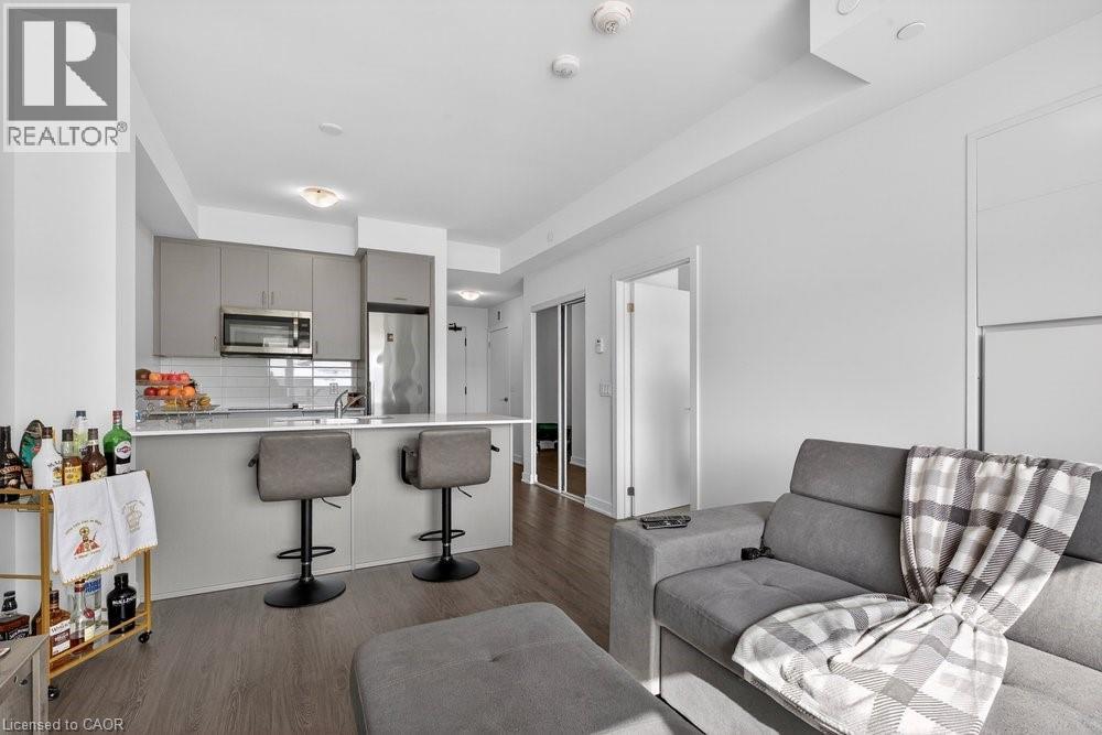 A modern living room with a grey couch and a bar area.