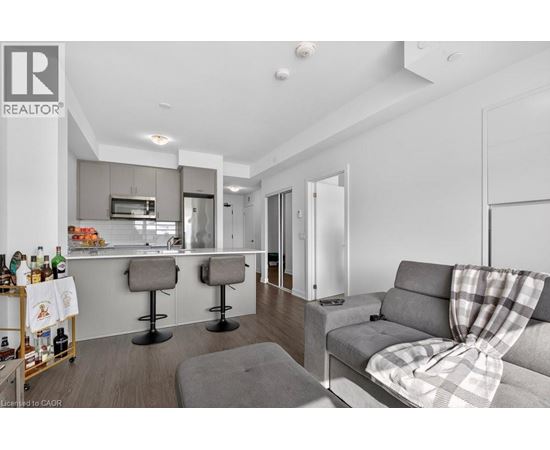A modern living room with a grey couch and a bar area.