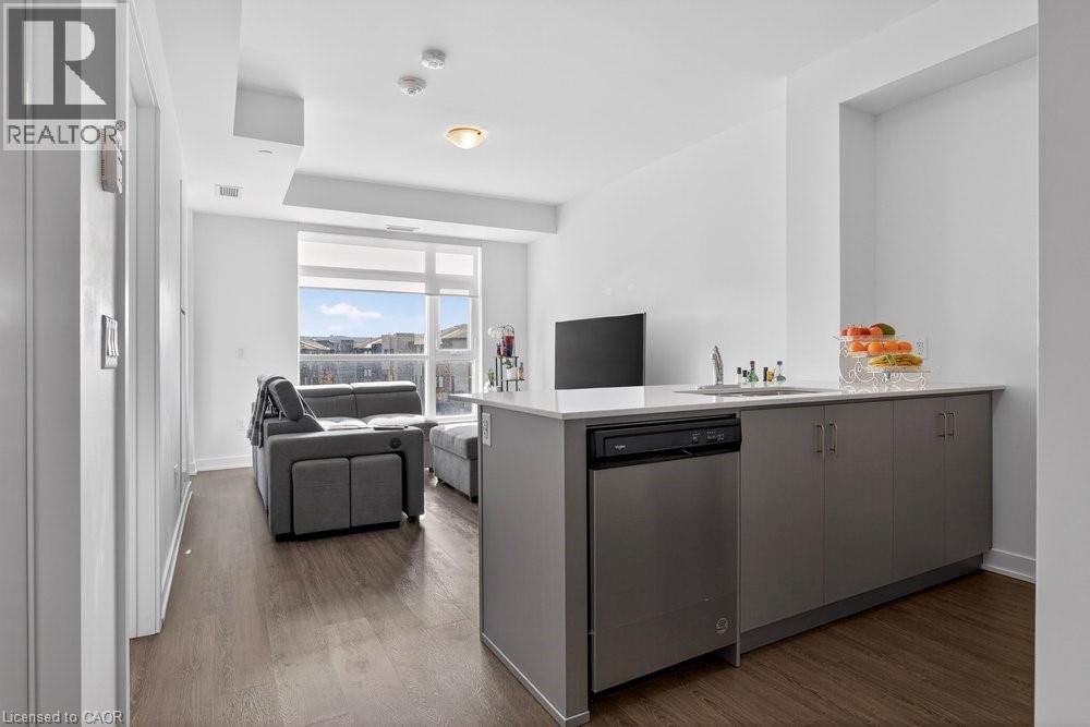 A modern kitchen with a grey cabinetry and a black fridge.