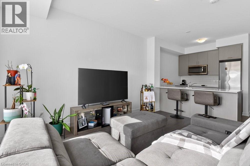 A modern living room with a grey sofa set and a black television.