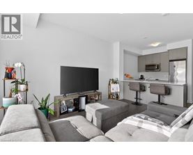 A modern living room with a grey sofa set and a black television.