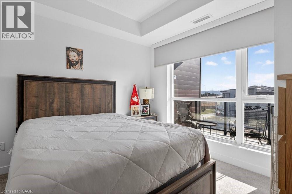 A bedroom with a large bed and a window overlooking a patio.
