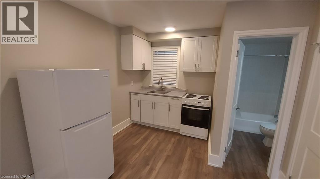 A small kitchen with a refrigerator, cabinets, and a stove top oven.