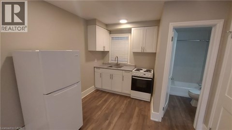 A small kitchen with a refrigerator, cabinets, and a stove top oven.