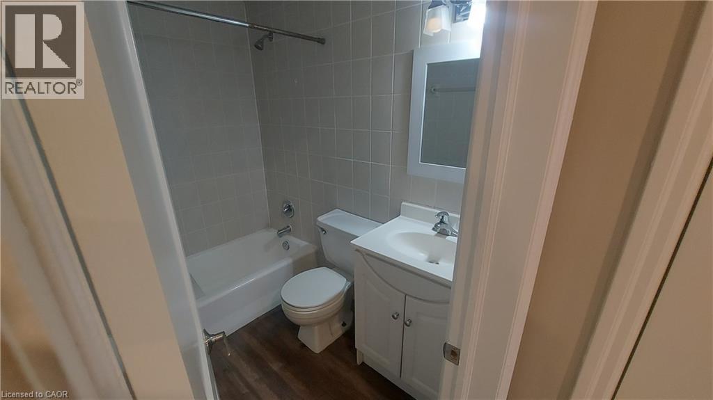 A bathroom with a toilet, sink, and shower.