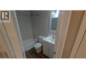 A bathroom with a toilet, sink, and shower.