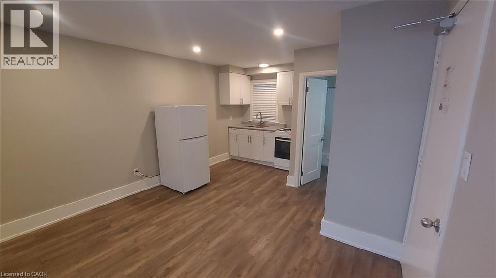 A kitchen area with a refrigerator, sink, and oven.