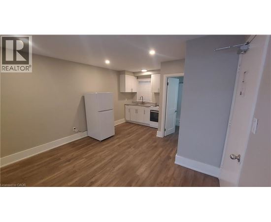 A kitchen area with a refrigerator, sink, and oven.