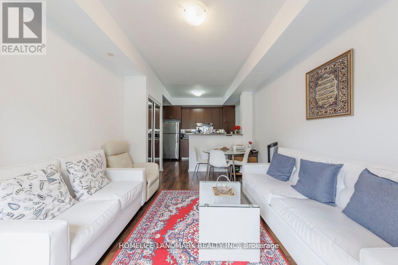 A living room with a white couch and a rug on the floor.